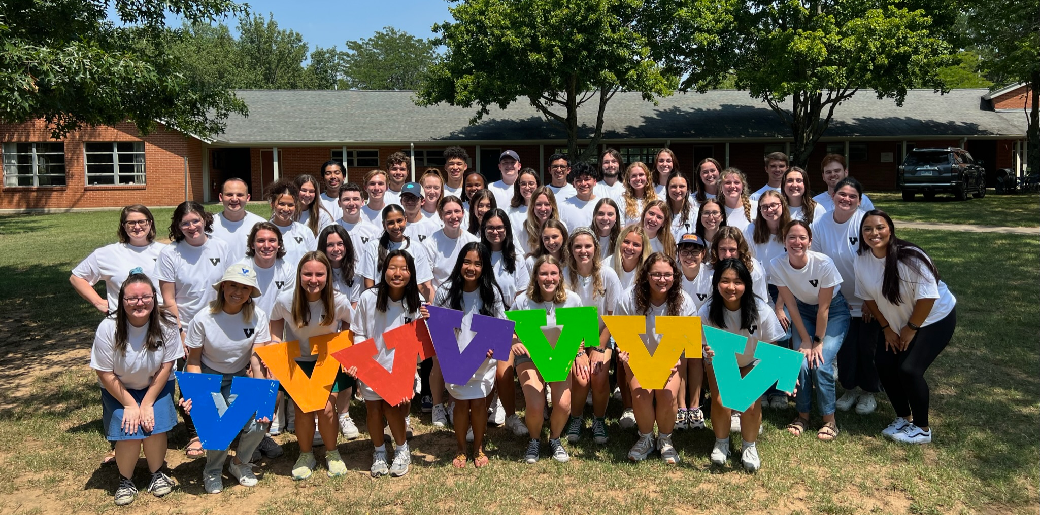  group of students gathering at VAC retreat holding brightly colored signs